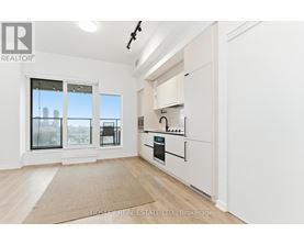 A kitchen with white cabinets and a beige rug on the floor.