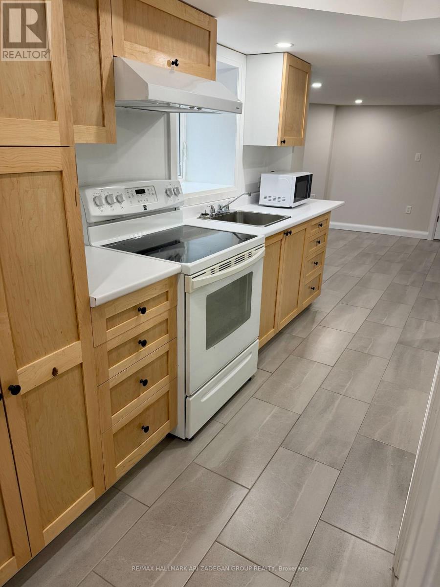 A kitchen with wooden cabinets and a white stove top oven.