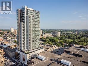 A tall building with a glass facade stands in the foreground of a cityscape.