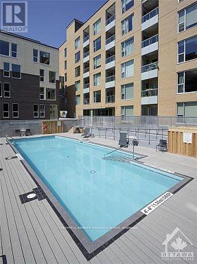 A swimming pool on a deck in front of apartment buildings.