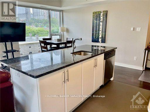 A kitchen with white cabinets and a black countertop.