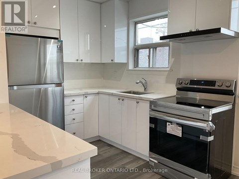 A kitchen with white cabinets and a stainless steel refrigerator.