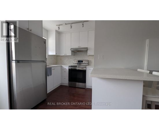 A kitchen with white cabinets and a stainless steel refrigerator.