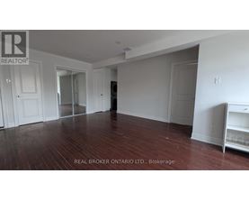 A room with wood flooring and white walls, with a white cabinet on the right.