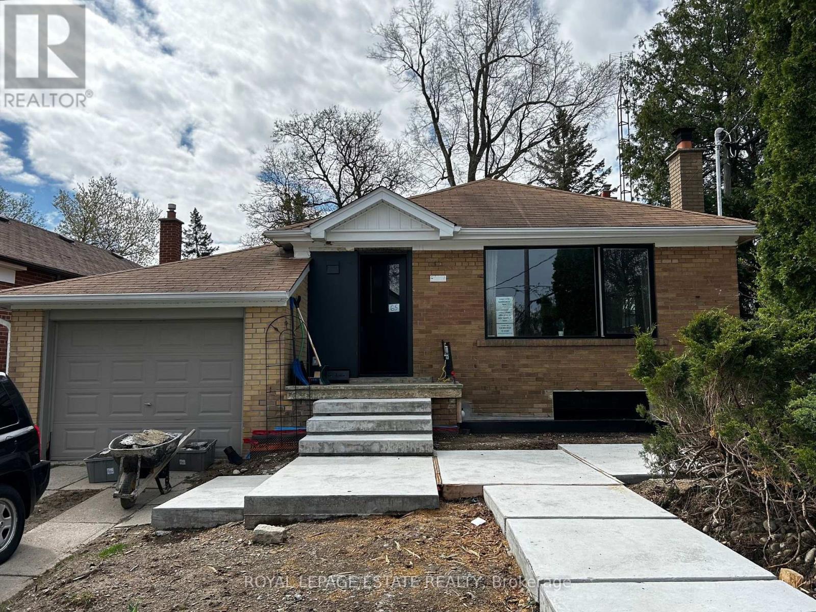 A house with a black door and a grey garage door.