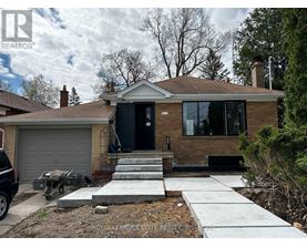 A house with a black door and a grey garage door.