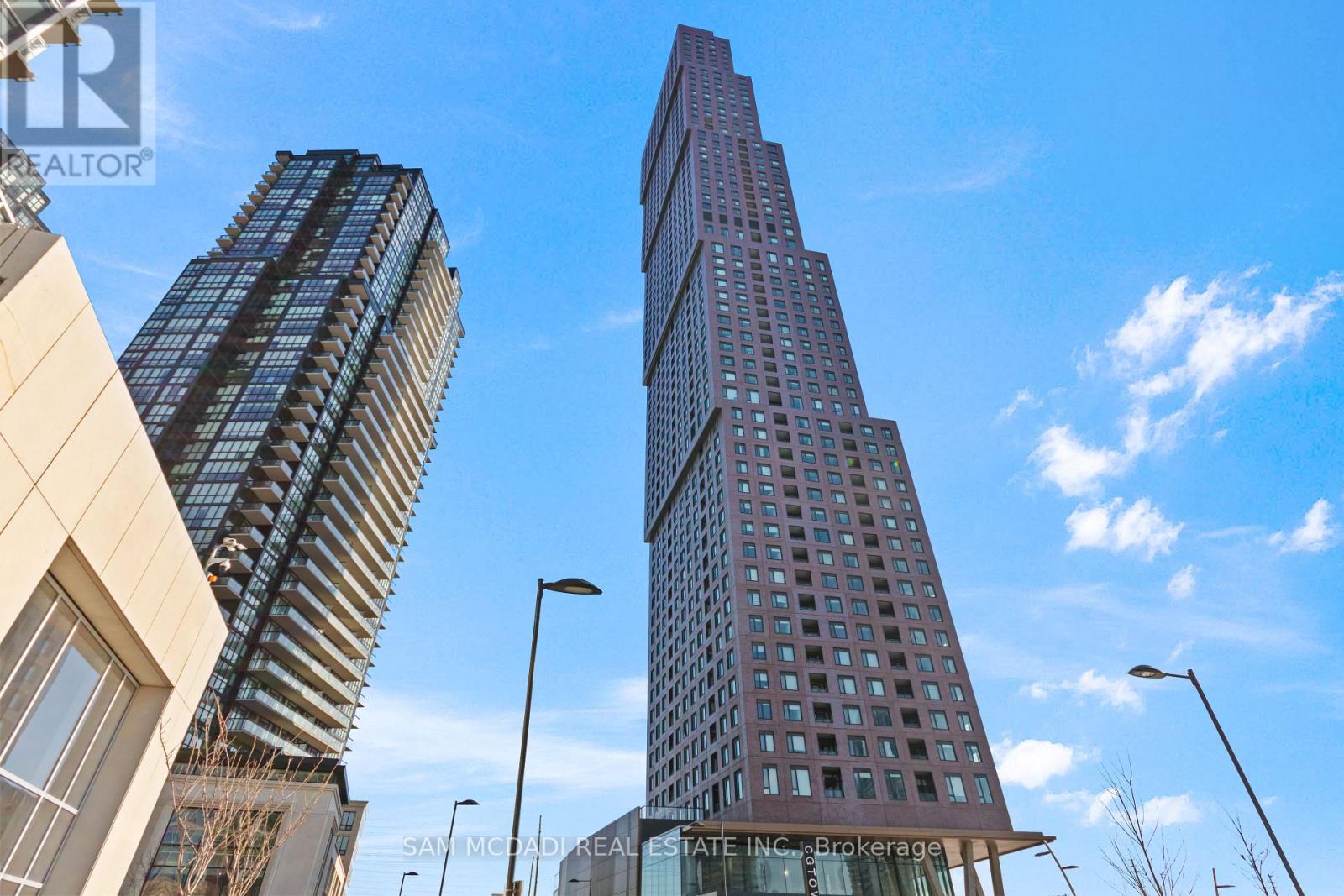 Two tall buildings are seen in the image with a clear blue sky in the background.