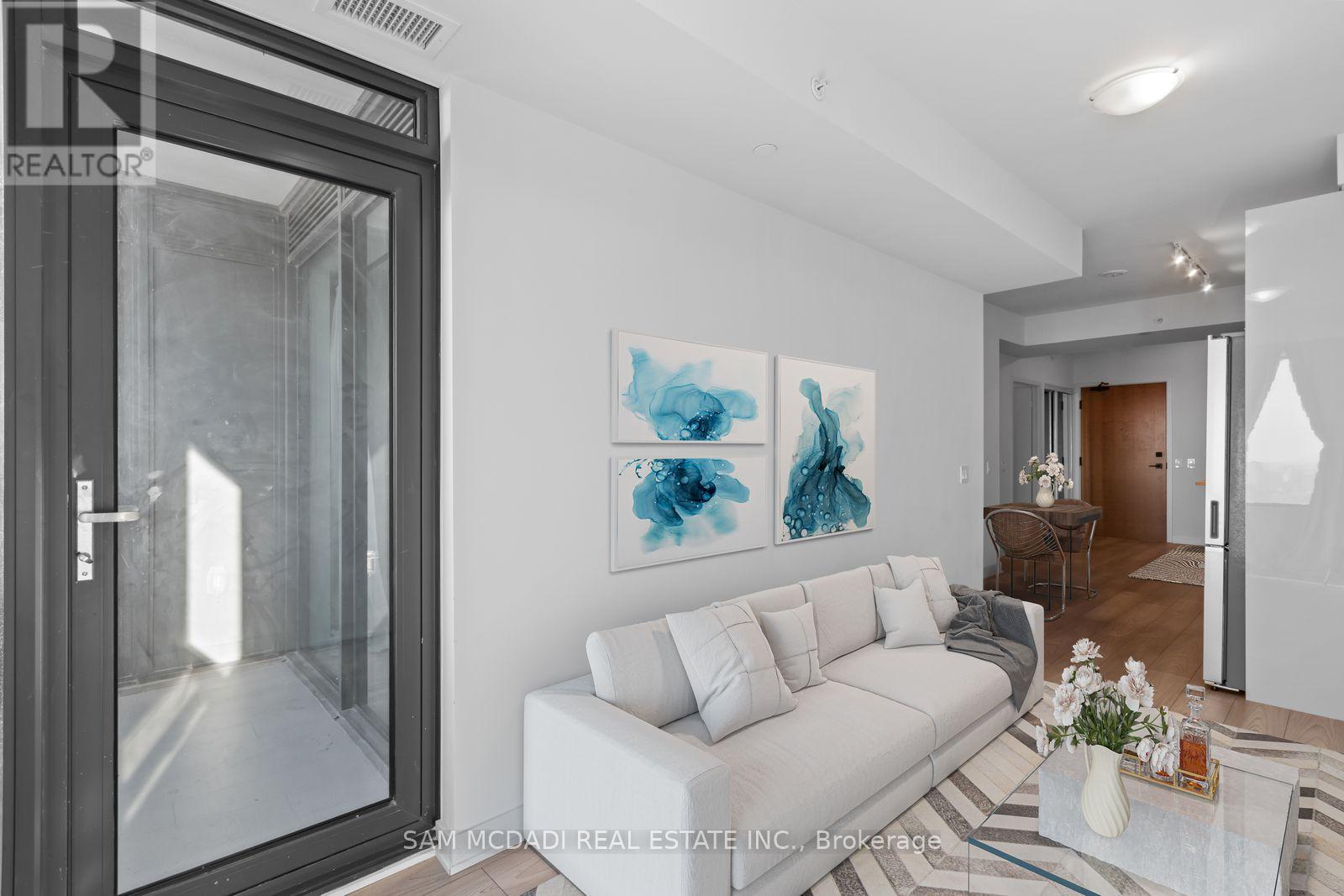 A living room with a glass door and a white couch.