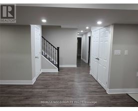 A hallway with a staircase and white doors.