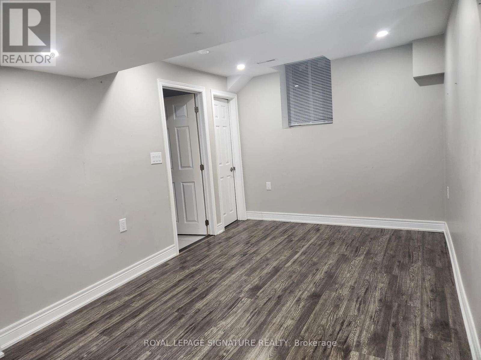 A room with wooden flooring and white walls.