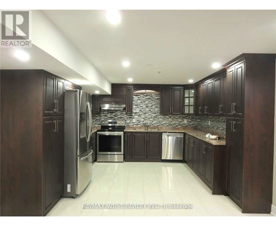 A kitchen with dark wood cabinets and stainless steel appliances.