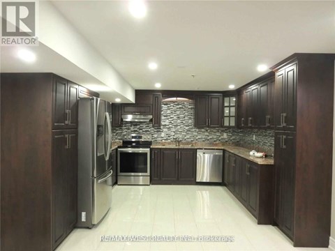 A kitchen with dark wood cabinets and stainless steel appliances.