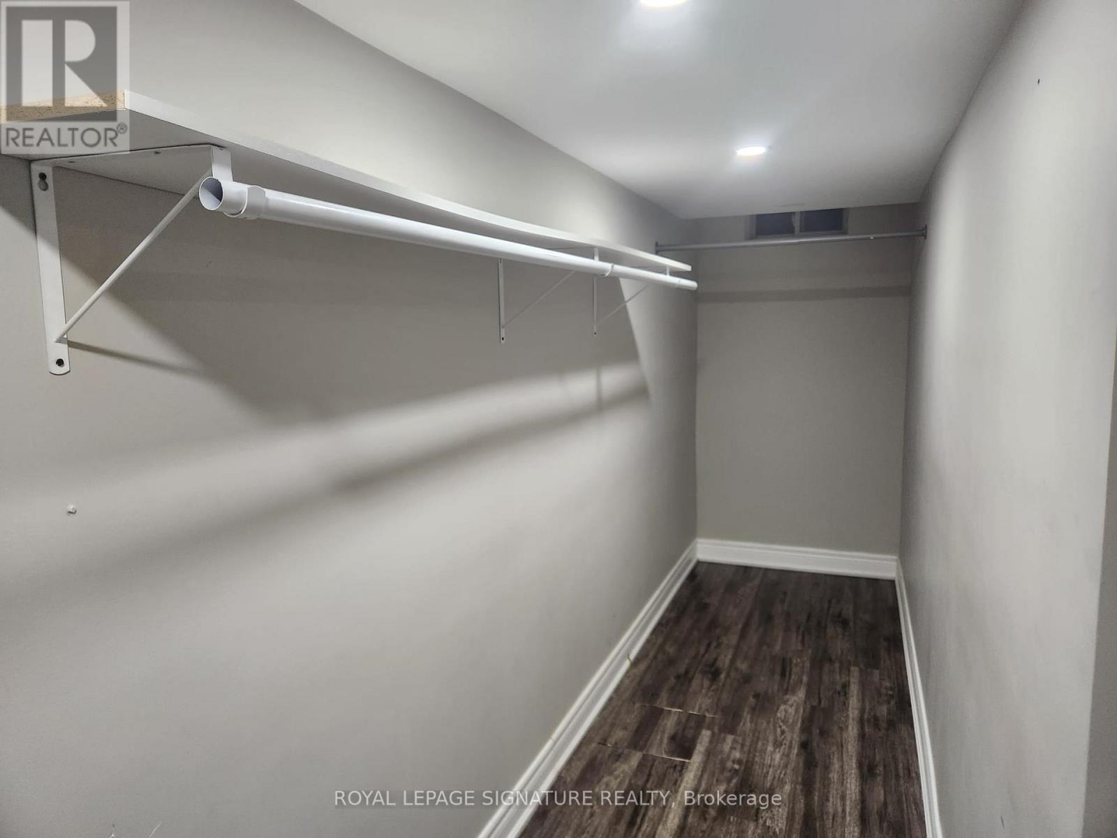 A white room with a wooden floor and a white ceiling.