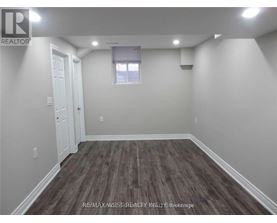 A room with wooden flooring and white walls.