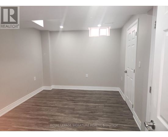 A room with wooden flooring and white walls.