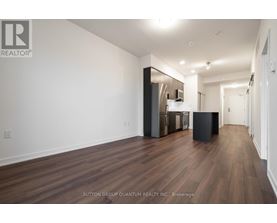 A spacious room with wooden flooring and white walls.