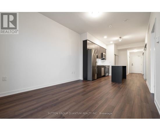 A spacious room with wooden flooring and white walls.