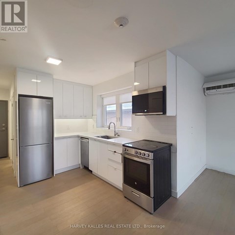 A kitchen with white cabinets and a black stove top oven.