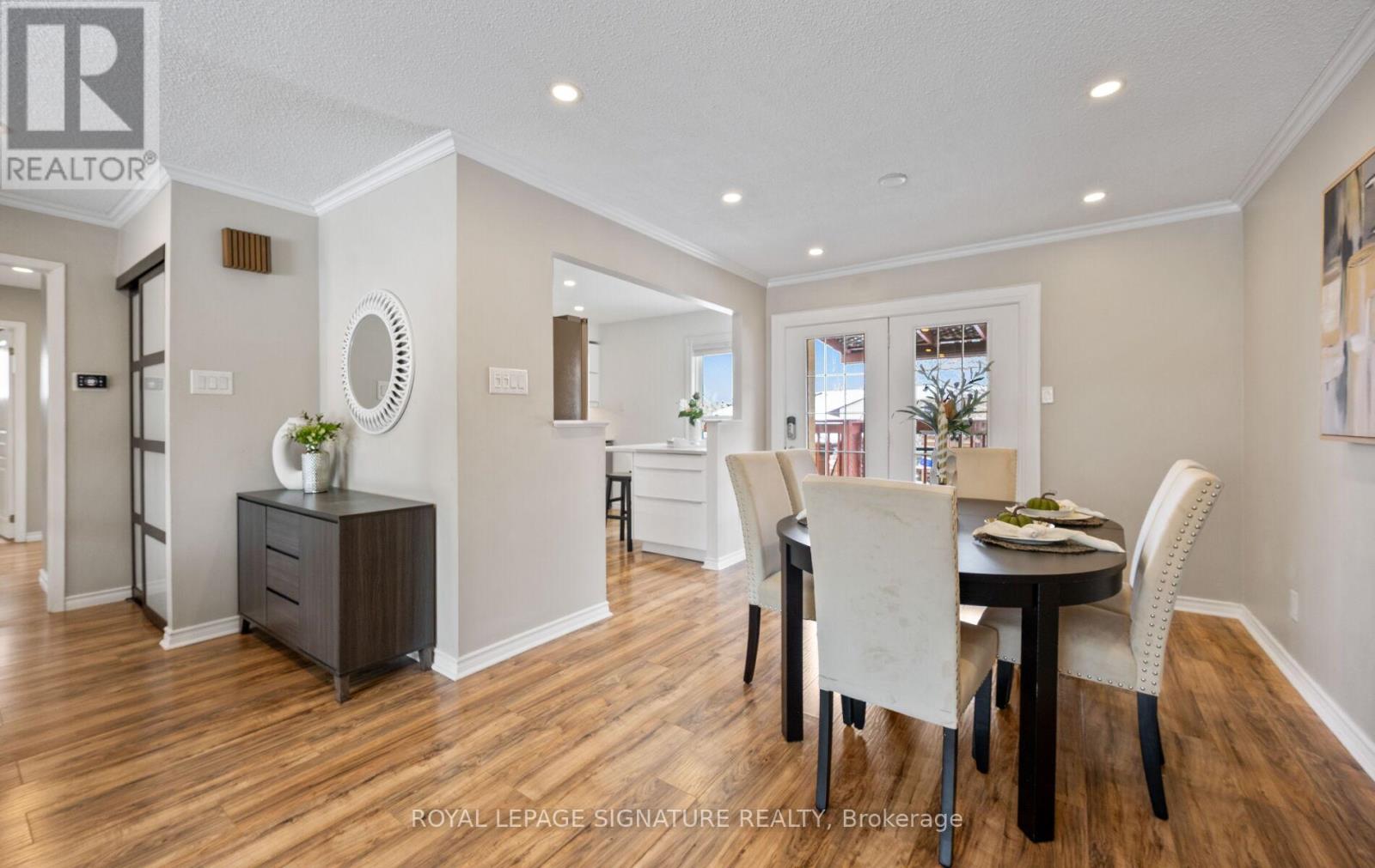 A dining room with a table set for two and a kitchen area in the background.
