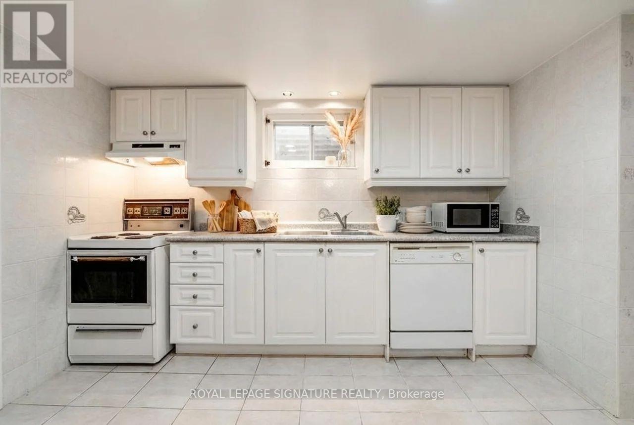 A white kitchen with a microwave on the counter.