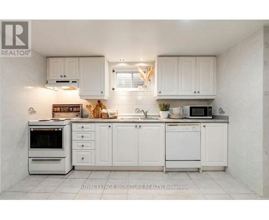 A white kitchen with a microwave on the counter.
