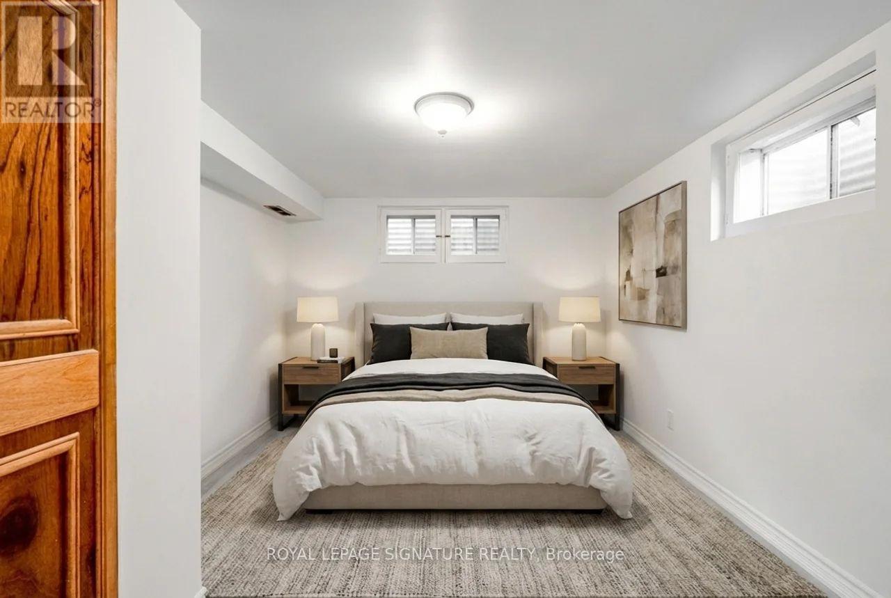 A bedroom with a bed, nightstands, and a painting on the wall.