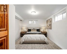 A bedroom with a bed, nightstands, and a painting on the wall.