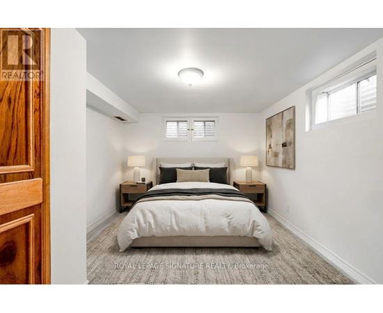 A bedroom with a bed, nightstands, and a painting on the wall.