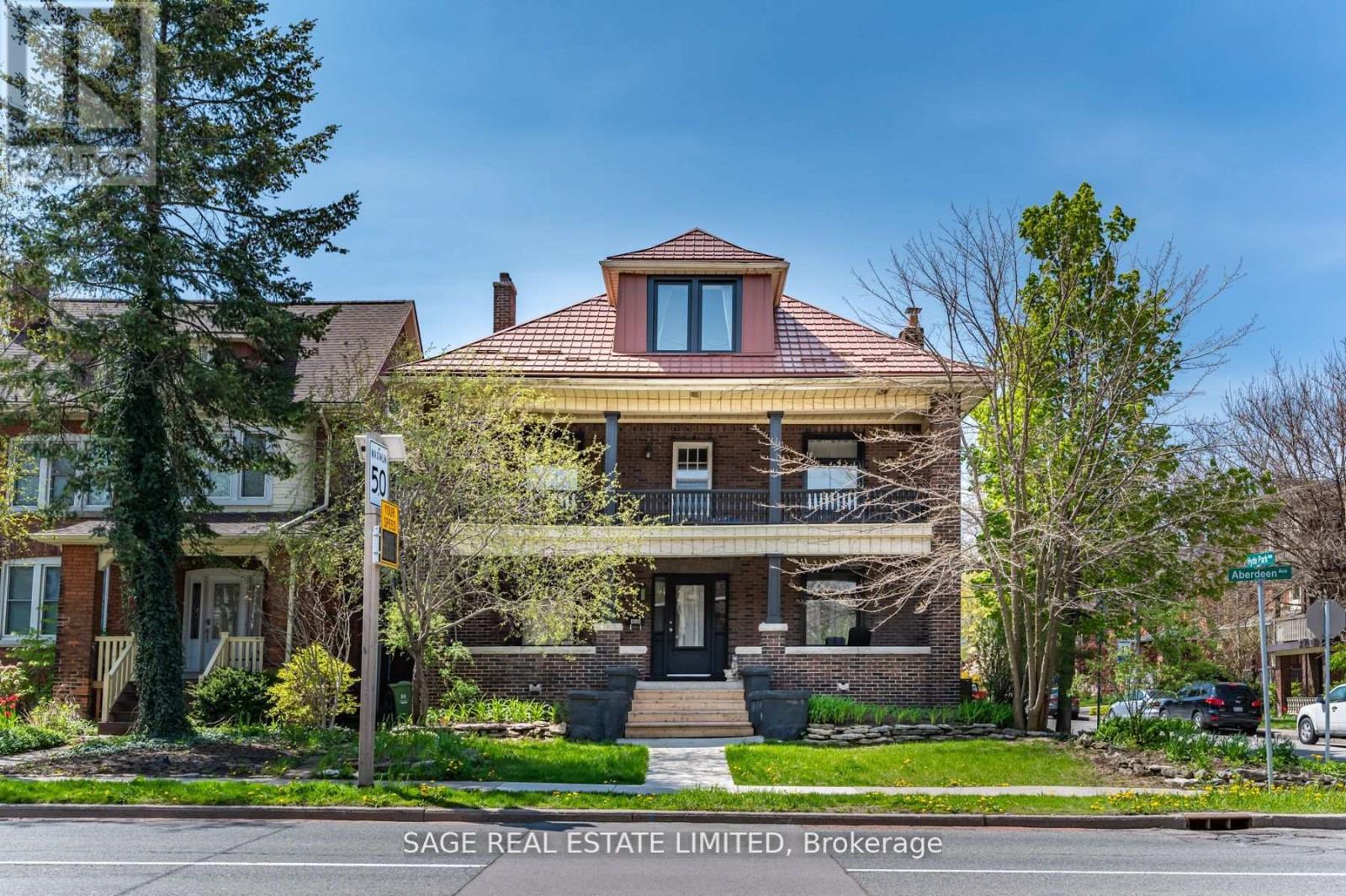A house with a red roof and a sign that says SAGE REAL ESTATE LIMITED, Brokerage.