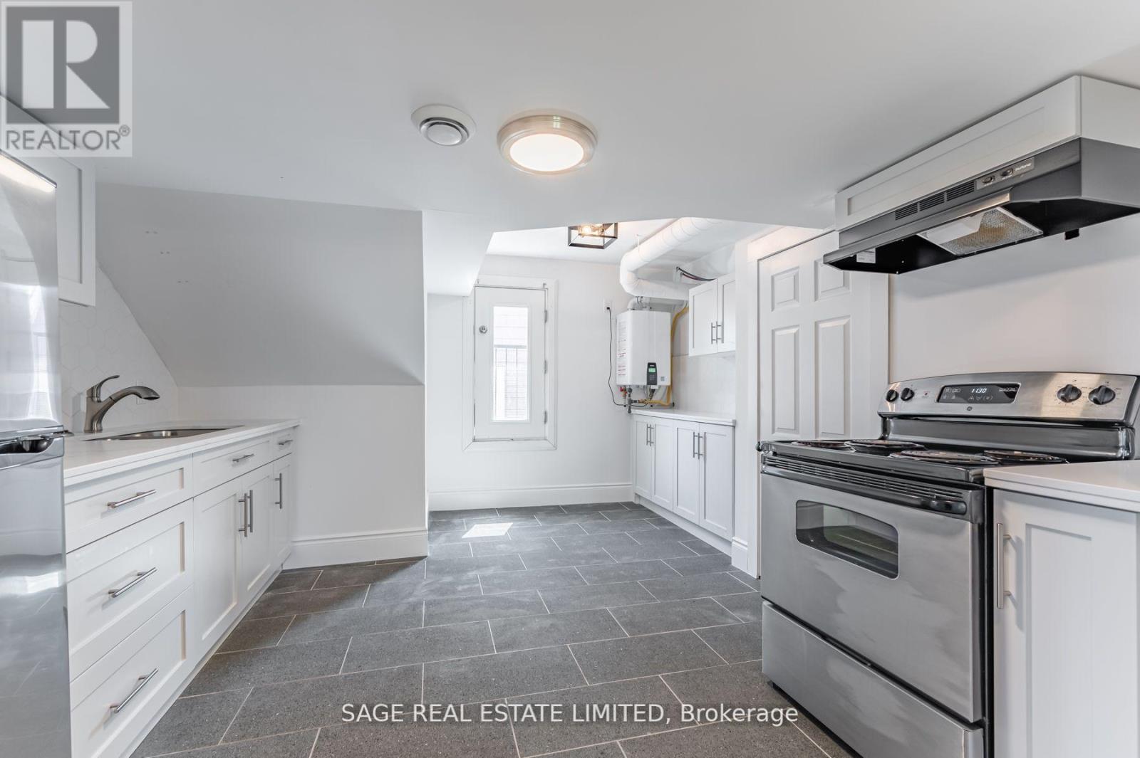 A kitchen with a stove top oven and a sink.