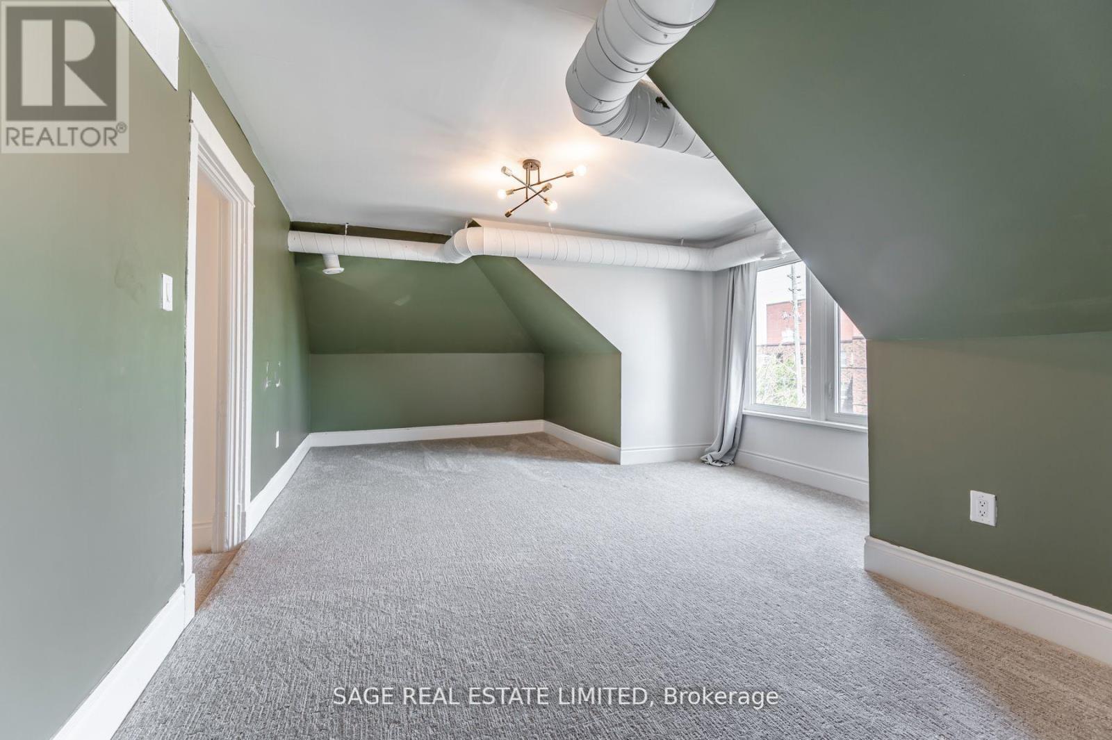 A room with a carpet floor and a ceiling fan.