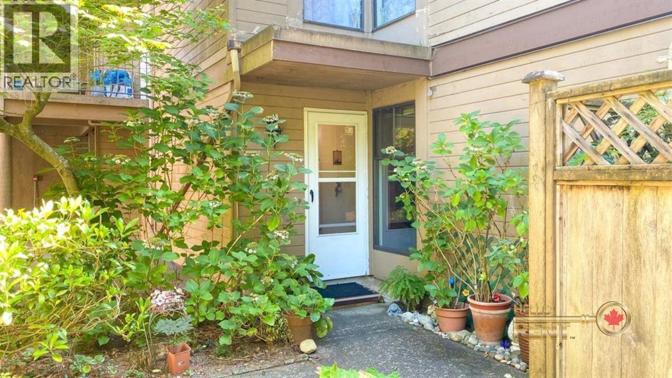 A small house with a white door and a small garden in front.