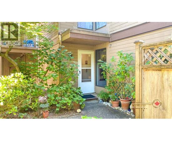 A small house with a white door and a small garden in front.