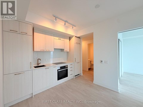 A kitchen with white cabinets and a black stove top oven.