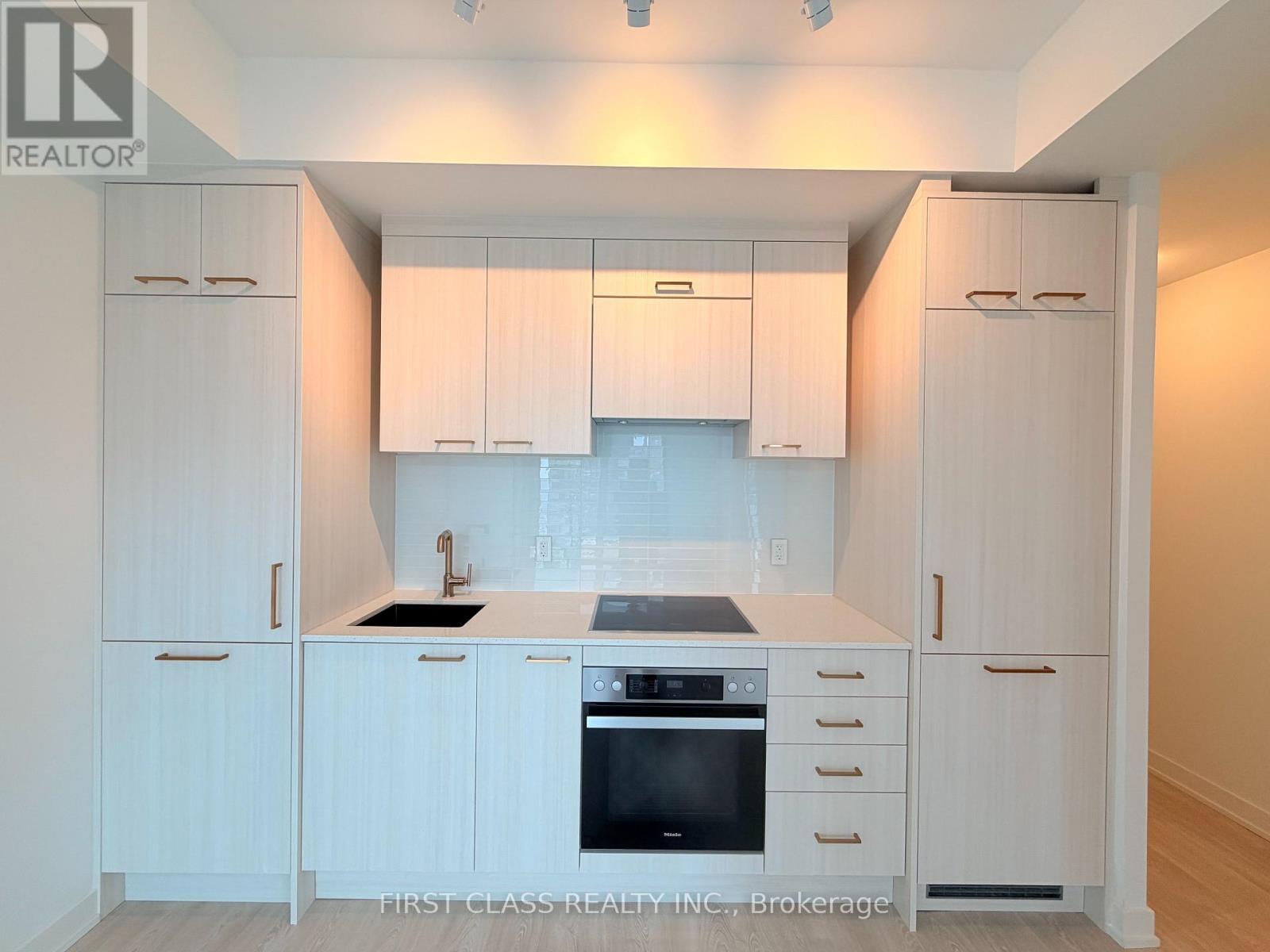 A kitchen with white cabinets and a black stove top oven.