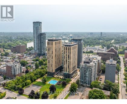 A cityscape with a tall building in the center and a pool in the foreground.
