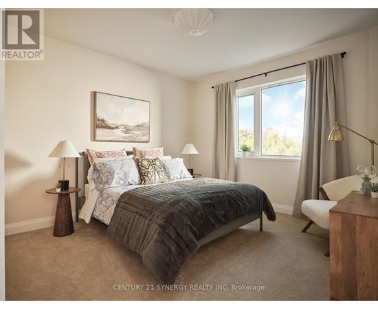 A bedroom with a large bed and a painting on the wall.