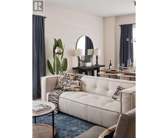 A living room with a white sofa and a round mirror on the wall.