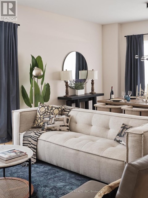 A living room with a white sofa and a round mirror on the wall.