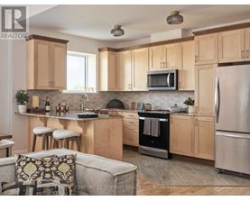 A kitchen with wooden cabinets and a stainless steel refrigerator.