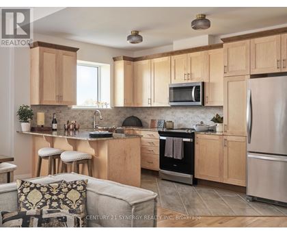 A kitchen with wooden cabinets and a stainless steel refrigerator.