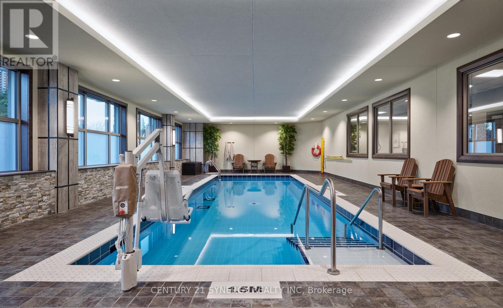 A swimming pool inside a building with a stone wall and a window.