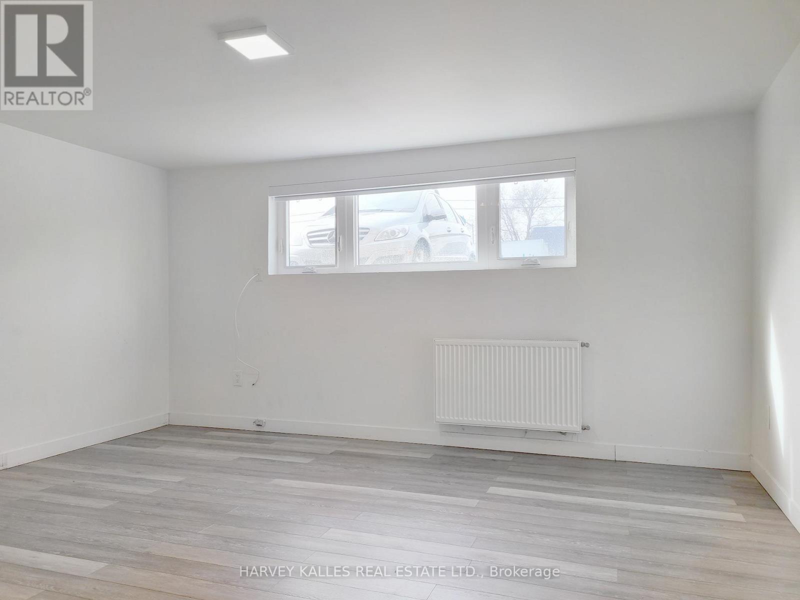 A room with a window and a radiator on the floor.