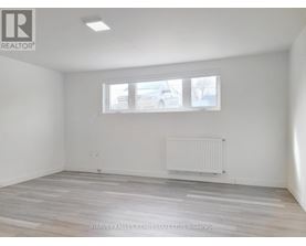 A room with a window and a radiator on the floor.