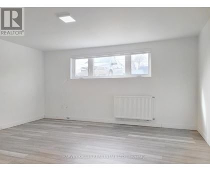 A room with a window and a radiator on the floor.