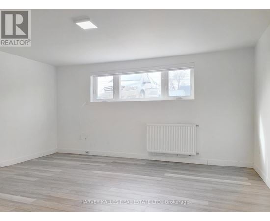 A room with a window and a radiator on the floor.