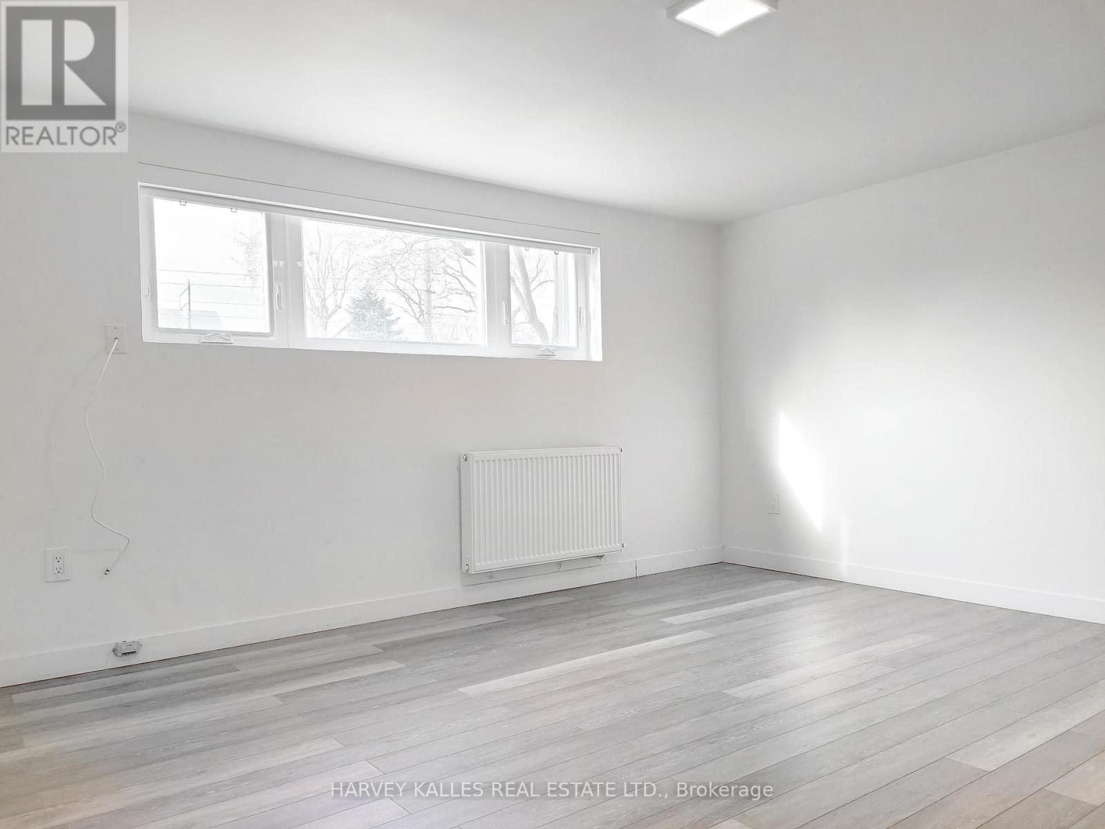 A room with a white wall and a window with a white frame.