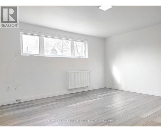 A room with a white wall and a window with a white frame.