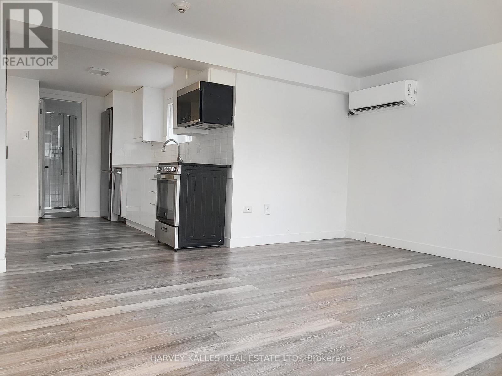 A spacious kitchen with white cabinets and a black stove top oven.