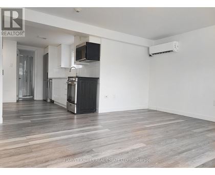 A spacious kitchen with white cabinets and a black stove top oven.